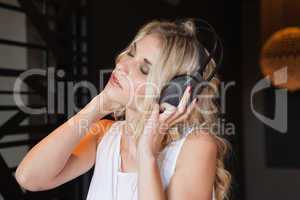 Pretty blonde listening to music with eyes closed