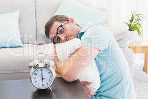 Bored man on the table beside alarm clock