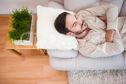 Man sleeping on the couch with arms crossed