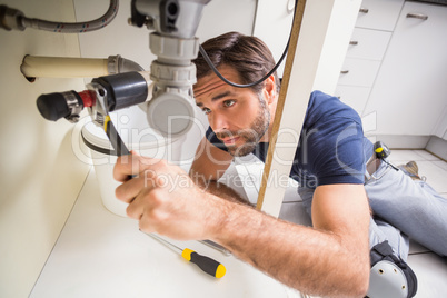 Plumber fixing under the sink