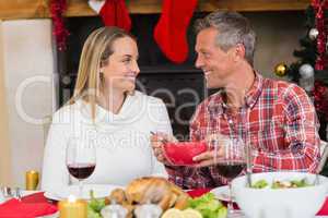 Man serving wife during the dinner