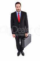 Serious handsome businessman holding briefcase