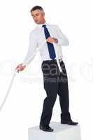 Businessman standing on a cube and pulling rope