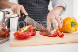 Woman slicing up red pepper