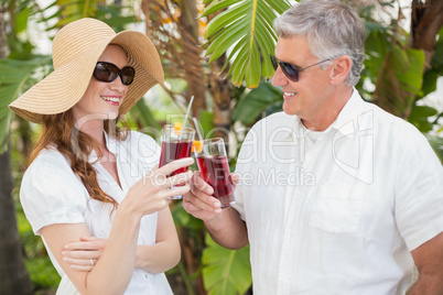 Holidaying couple toasting with cocktails