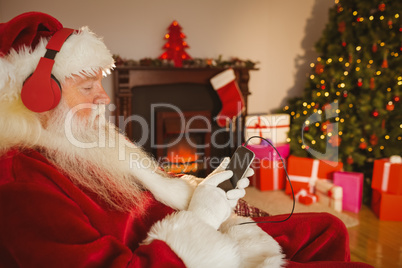Santa claus listening music with his smartphone