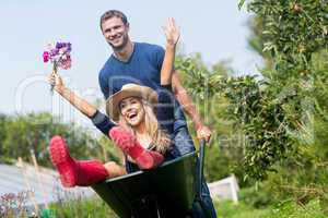 Man pushing his girlfriend in a wheelbarrow