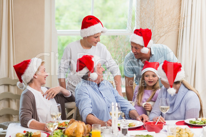 Happy extended family in santa hat speaking together