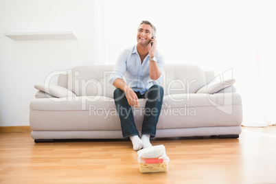 Smiling man phoning on the couch