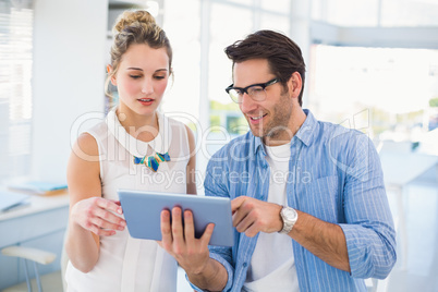 Cheerful photo editors working together on tablet pc