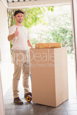 Delivery man with trolley of boxes giving thumbs up