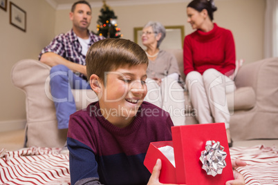 Happy son lying and opening gift