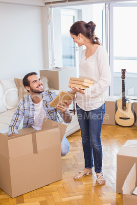 Cute couple unpacking cardboard boxes