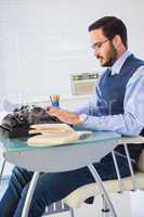 Businessman working on typewriter while smoking