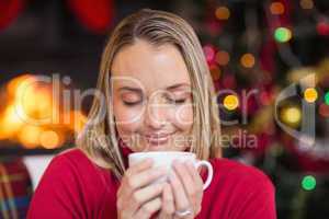 Pretty blonde enjoying a hot drink at christmas