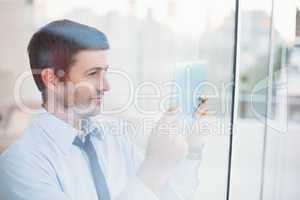 Businessman using tablet seen through window