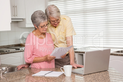 Senior couple paying their bills with laptop