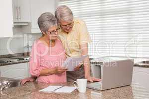 Senior couple paying their bills with laptop