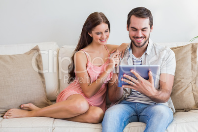 Hipster couple using tablet on couch