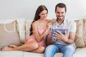 Hipster couple using tablet on couch