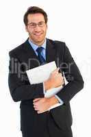 Smiling businessman holding his laptop looking at camera