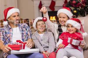 Festive family wearing santa hat on the couch