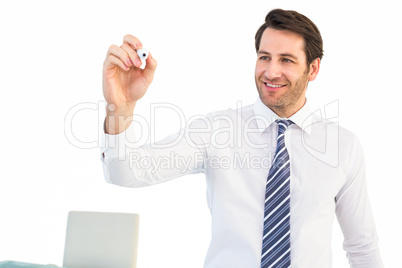 Smiling businessman writing with black marker