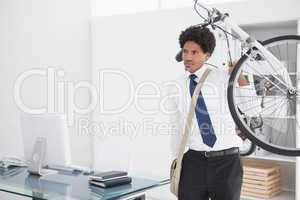 Attractive businessman carrying his bike