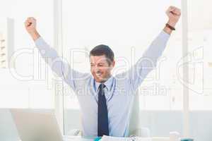 Cheering businessman at his desk