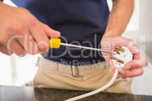 Electrician working at plug socket