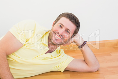 Smiling man lying on the floor at home