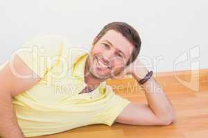 Smiling man lying on the floor at home