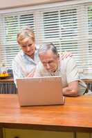 Senior couple using the laptop together