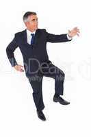 Businessman posing with one foot on floor and arms out