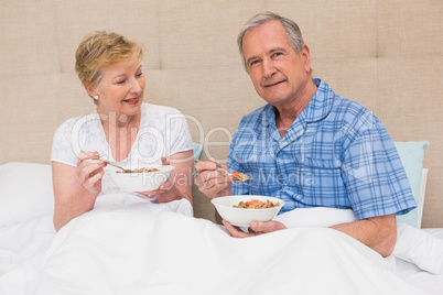 Senior couple having breakfast in bed