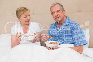 Senior couple having breakfast in bed