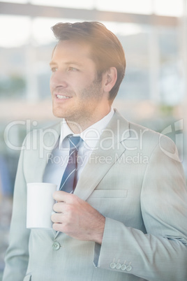 Handsome businessman holding cup of coffee