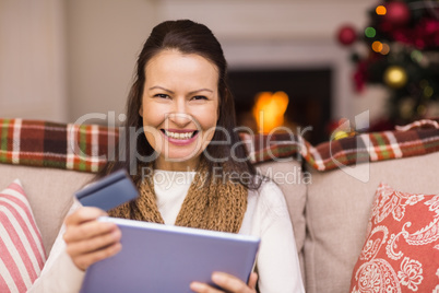 Brunette shopping online with laptop at christmas