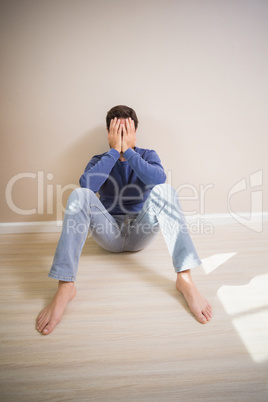 Depressed man sitting on floor