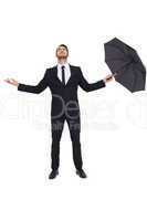 Businessman with arm out holding umbrella