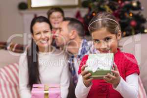 Happy little girl opening a gift