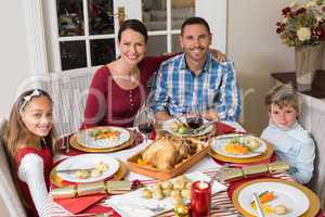 Smiling family looking at camera during christmas dinner