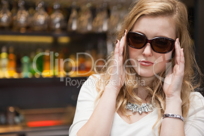 Pretty blonde woman in sunglasses posing