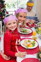 Little girl and mother in party hat smiling at camera