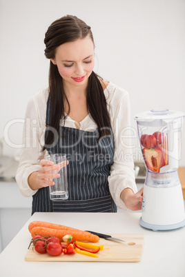 Pretty brunette preparing a healthy juice
