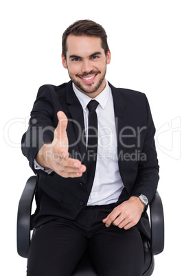 Smiling businessman on an chair office offering handshake Smiling businessman on an chair office offering handshake
