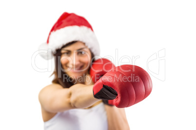 Festive brunette in boxing gloves punching