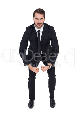 Smiling elegant businessman flexing muscles