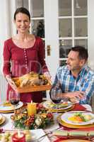 Couple smiling while woman holding roast turkey