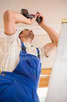 Handyman using a cordless drill to the ceiling